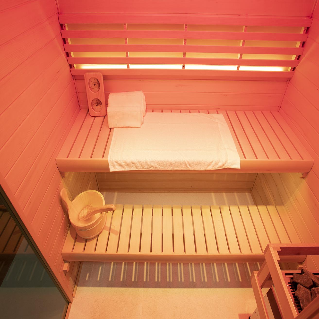 Samsora 703SH interior detail close-up - Canadian hemlock craftsmanship showcasing therapeutic 660nm red light panels, spacious three-person bench seating and natural wood grain