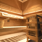  Samsora 704VT outdoor sauna interior features - African mahogany craftsmanship with therapeutic 660nm red light panels, spacious four-person bench seating and collagen-boosting ambiance